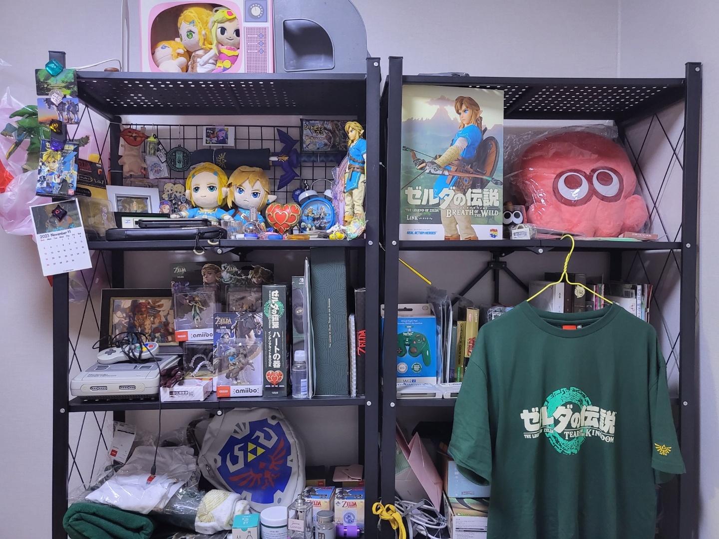 그동안 모은 젤다, 마리오, 스플래툰, 커비 굿즈들을 정리했습니다. 젤다의 전설 티셔츠 뒤엔 제가 참여한 책과 개인적으로 팬심으로  구매한 책들과 참고서가 있네요. | 콜리(Colley)